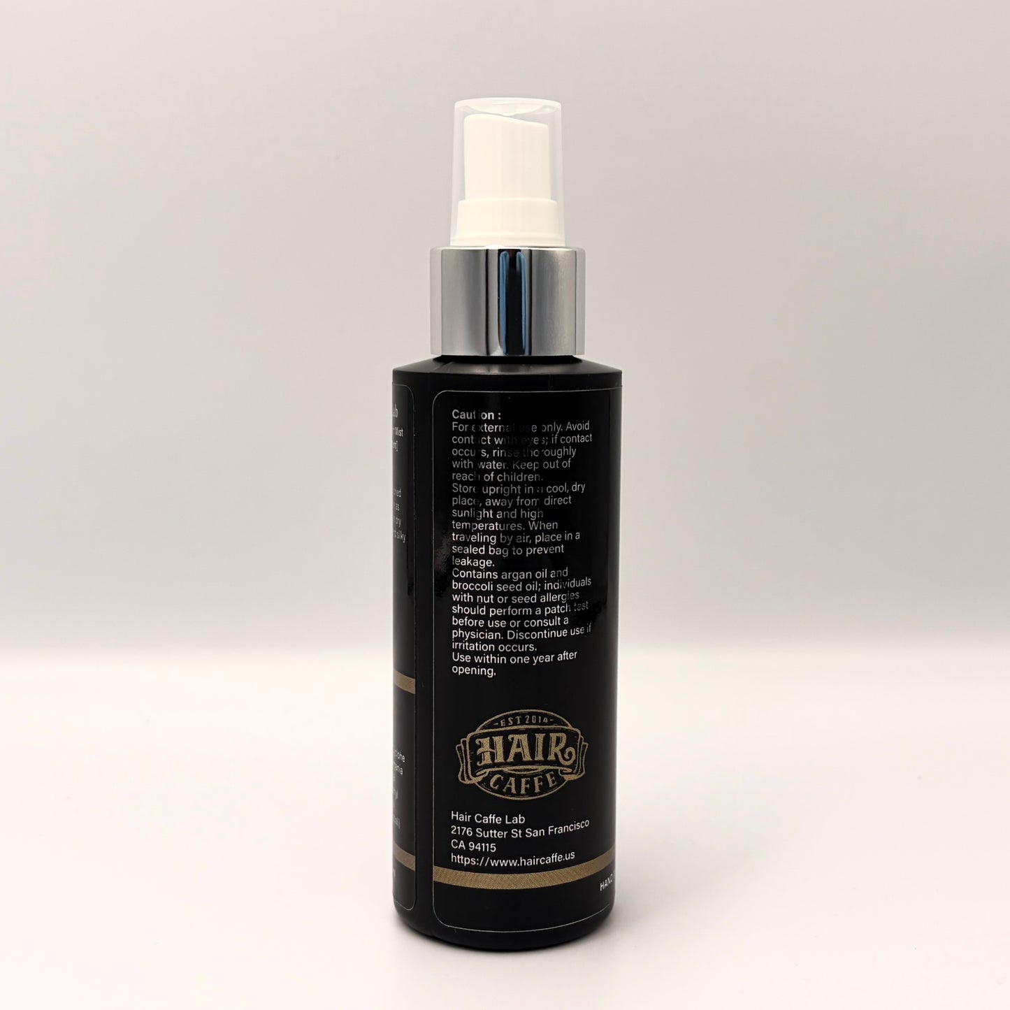 No.115 side panel showing the caution statement, the argan and broccoli seed oil nut allergy warning, and the Hair Caffe est. 2014 emblem
