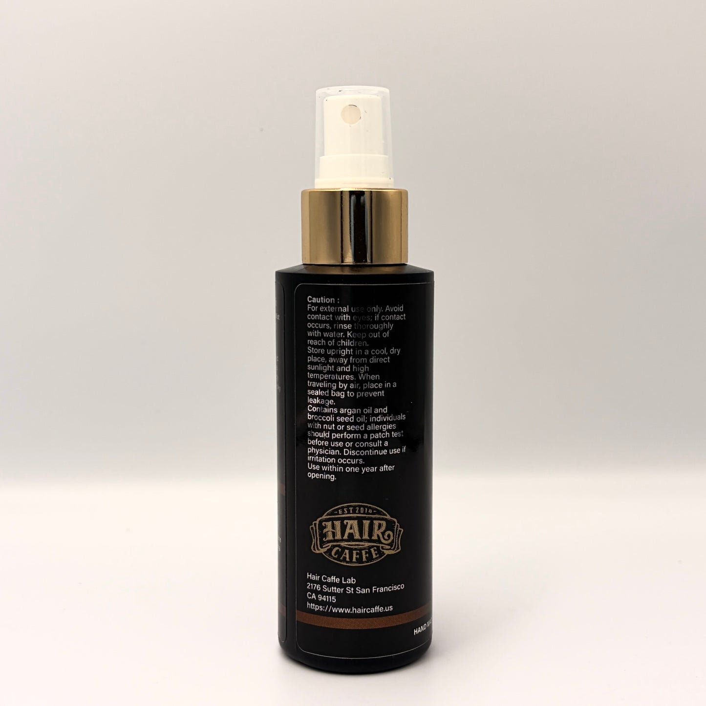 No.215 side panel showing the caution statement, the argan and broccoli seed oil nut allergy warning, and the Hair Caffe est. 2014 emblem