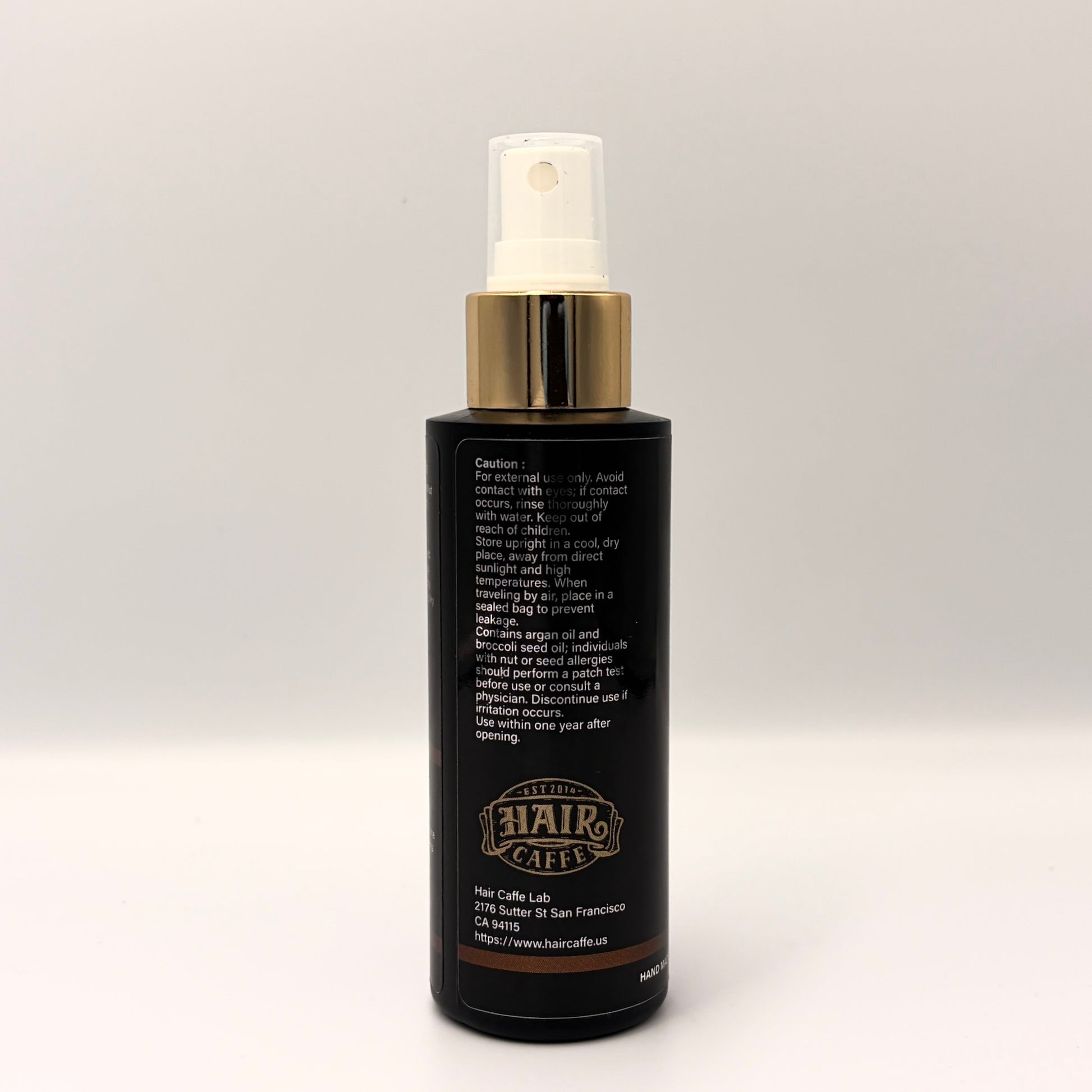 No.215 side panel showing the caution statement, the argan and broccoli seed oil nut allergy warning, and the Hair Caffe est. 2014 emblem
