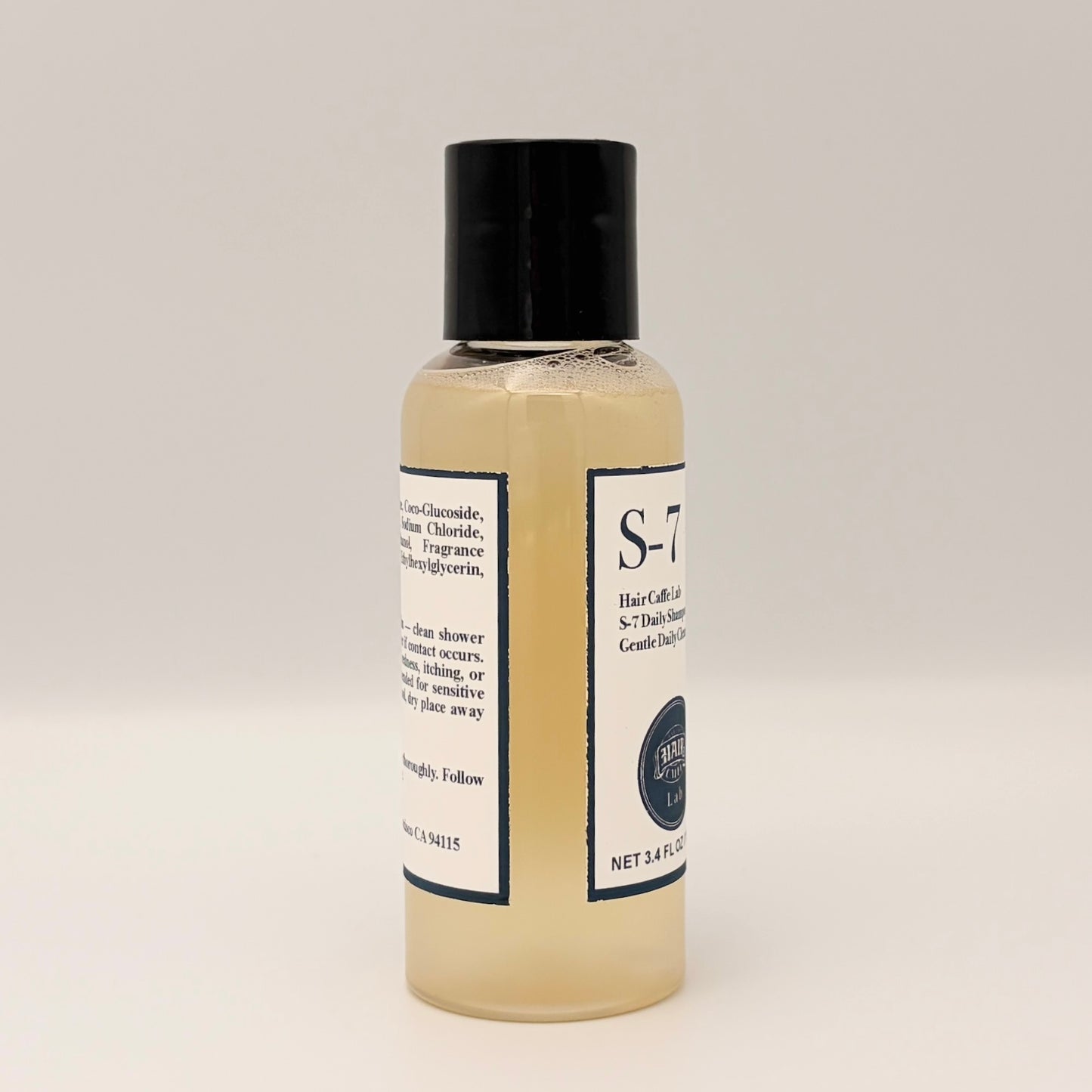 S-7 Daily Shampoo travel size bottle, angled view showing front and back labels