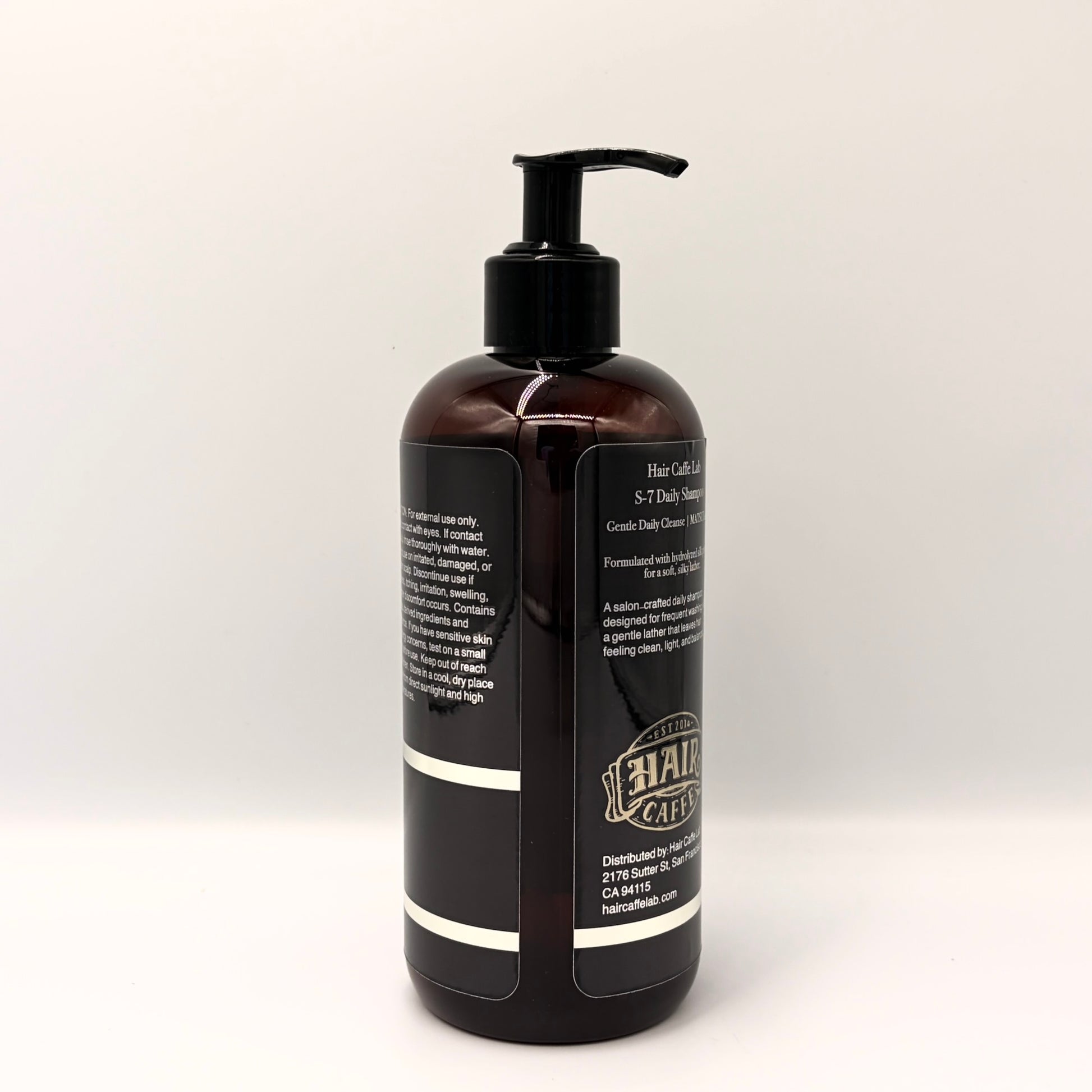 S-7 Daily Shampoo bottle angled to show the back panel and the Hair Caffe est. 2014 emblem